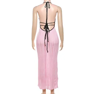 Detailed back view of a pink knitted halter maxi dress with stylish black tie-back details