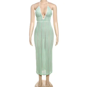 Elegant mint green halter neck knit maxi dress with a deep V-neckline and white trim detail.