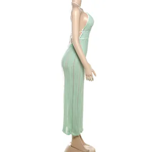 Side profile of a mint green knitted halter neck backless maxi dress with white trim
