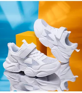 Breathable white mesh kids sports shoes on a reflective surface for school runners