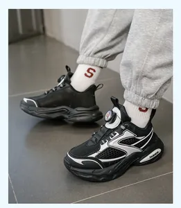 Detailansicht der klobigen schwarzen Jungen-Sneaker mit Drehverschluss-System am Modell.