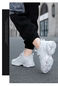 Detalle de zapatillas de cuero blanco para niños con suela antideslizante y cierre de velcro