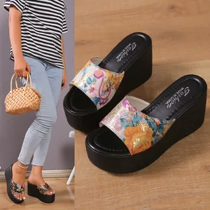 Close-up view of women's floral wedge platform sandals with thick black soles detail