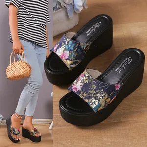 Detailed view of floral printed strap wedge platform sandals with thick black soles