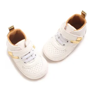 Detailed close-up of white baby pre-walker sneakers with soft soles and gold accents.