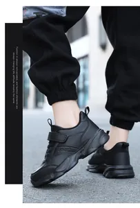 Vista lateral de zapatillas deportivas negras transpirables para niños con velcro