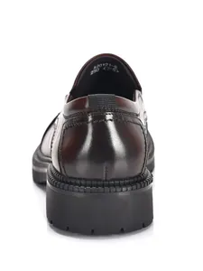 Vista trasera de zapato de cuero marrón con suela gruesa y pespuntes