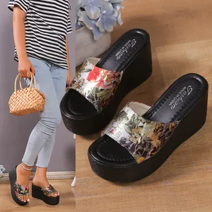 Detailed view of women's floral print wedge platform sandals with black thick soles.
