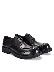 Vista dettagliata di scarpe stringate da uomo in vera pelle nera con suola spessa di qualità.