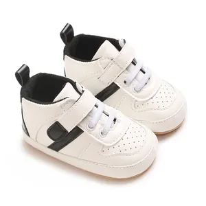 Close-up detail of white baby walking shoes with black stripes and soft non-slip soles