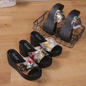 Macro view of floral print straps and textured platform soles on stylish wedge sandals.