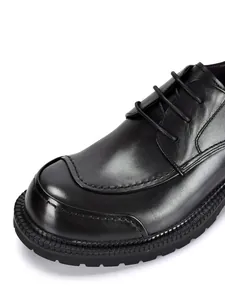 Primo piano di scarpa business in pelle nera con cuciture dettagliate e suola spessa