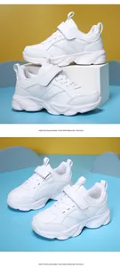 Vista detallada de zapatillas blancas para niños con suelas duraderas y velcro.
