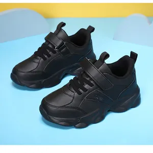 Vista lateral de zapatillas deportivas negras para niños con acabado en piel y cierre velcro