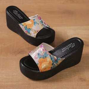 Detail of women's wedge sandals with vibrant floral print straps and thick platform soles