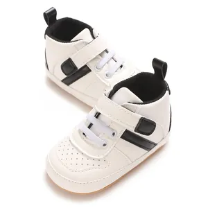 Detailed view of white and black baby walking shoes with soft soles and adjustable velcro straps