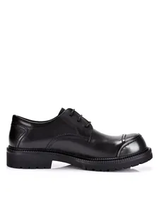 Vista laterale di scarpe derby eleganti da uomo in pelle nera con suola spessa.