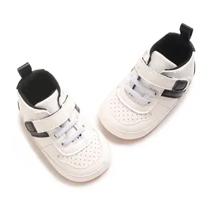Detailed view of baby white sneakers with soft soles and black stripe accents for boys