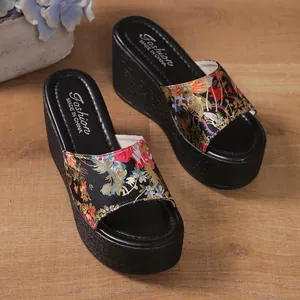 Detailed view of the vibrant ethnic floral pattern on these stylish black wedge platform slides