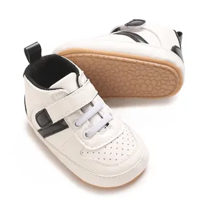 Top-down view of white infant walking shoes with black stripes and soft soles
