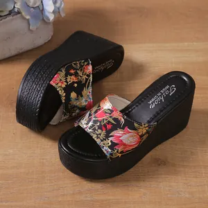 Detailed view of the vibrant floral print and textured platform sole on wedge slippers