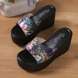 Close-up detail of the floral print strap and thick black platform on wedge sandals
