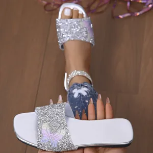 Dettaglio del sandalo argentato scintillante con bella decorazione a farfalla in strass luminosi