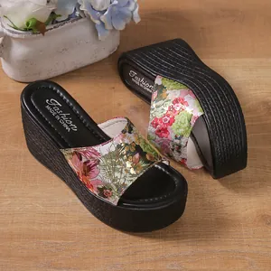 Detailed view of colorful floral pattern and thick platform on women's wedge slippers