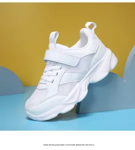 Vista lateral de zapatillas deportivas blancas para niños con malla y cierre velcro
