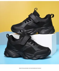 Detalle de perfil de zapatillas deportivas negras transpirables para niños con velcro