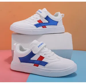 Vista laterale dettagliata di sneaker per bambini in pelle bianca con dettagli blu e rossi.