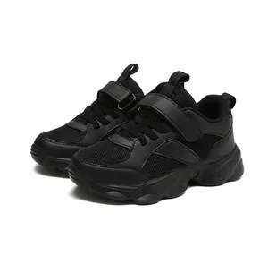 Primer plano de zapatillas deportivas negras para niños con malla transpirable y velcro