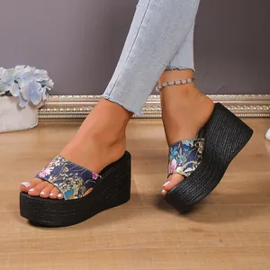 Close-up of floral print wedge platform sandals worn by a model in a casual setting