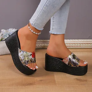 Macro detail of floral print platform wedge sandals featuring black woven texture sole