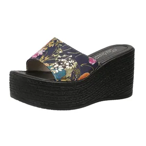 Floral pattern wedge slippers with thick woven platform sole and comfortable round toe design.