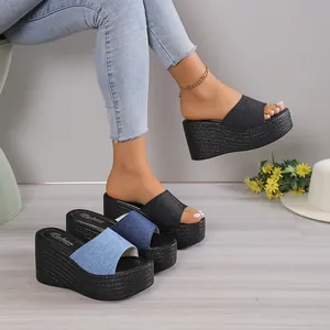 Detailed view of women's stylish denim platform wedge sandals in blue and black denim fabric