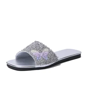 Vista dettagliata del sandalo glitter argento con decorazione a farfalla colorata lucida