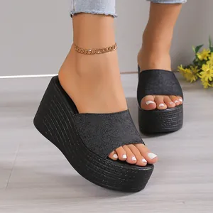 Close-up detail of women's black denim platform wedge sandals for summer
