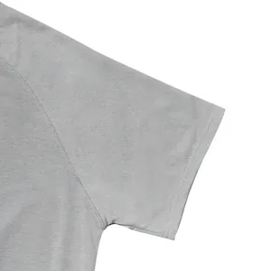 Detailed macro view of grey short-sleeved T-shirt showing fine stitching and cotton texture