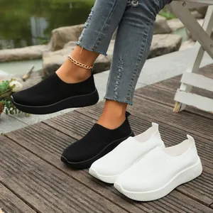 Lifestyle view of women's breathable flyknit slip-on sneakers in black and white variants