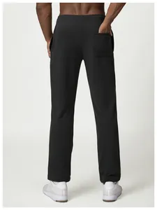 Detail view of men's loose black sweatpants showing rear pocket and comfortable casual fit