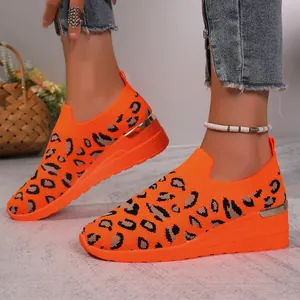 Detail view of orange leopard print wedge sneakers featuring breathable flyknit mesh upper