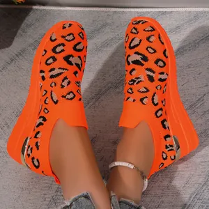 Detail shot of orange leopard print fly-knit slip-on sneakers with wedge soles for women.