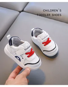 Close-up of white breathable mesh toddler shoes with red laces and Velcro strap