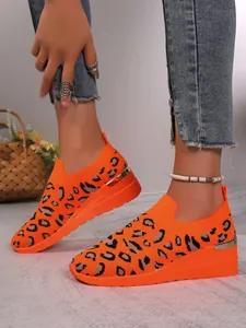 Detail view of stylish orange leopard print fly-knit upper on women wedge sneakers