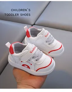 Detail view of white breathable mesh toddler shoes with red accents and Velcro strap