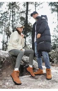 Vista de estilo de vida de pareja con botas de nieve marrones cálidas en un bosque
