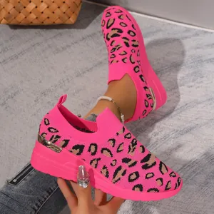 Close-up of women's pink leopard print platform slip-on sneakers in fly-knit material.