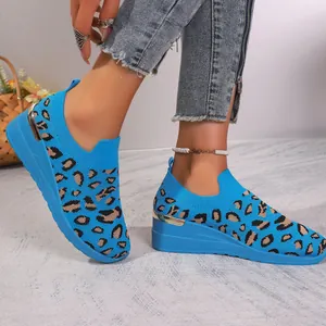 Close-up showing the blue leopard print fly-knit mesh fabric of these wedge sneakers.