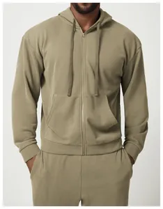 Dettaglio di un set felpa con cappuccio e zip verde oliva da uomo con tasca frontale.